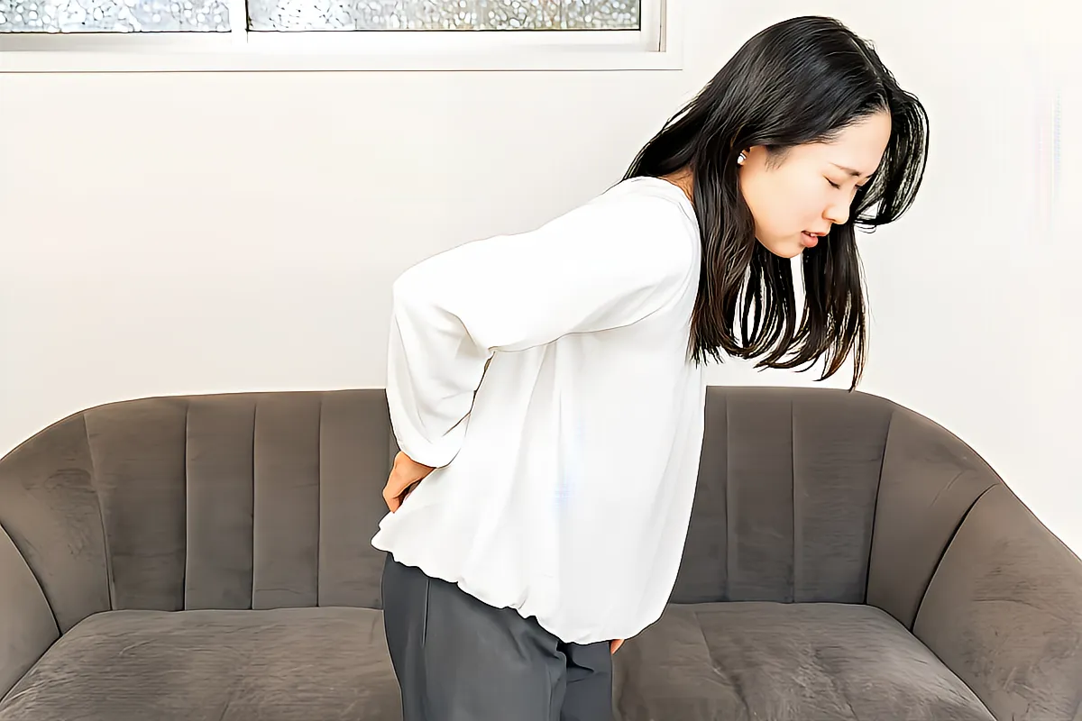 腰痛に悩む女性のイメージ
